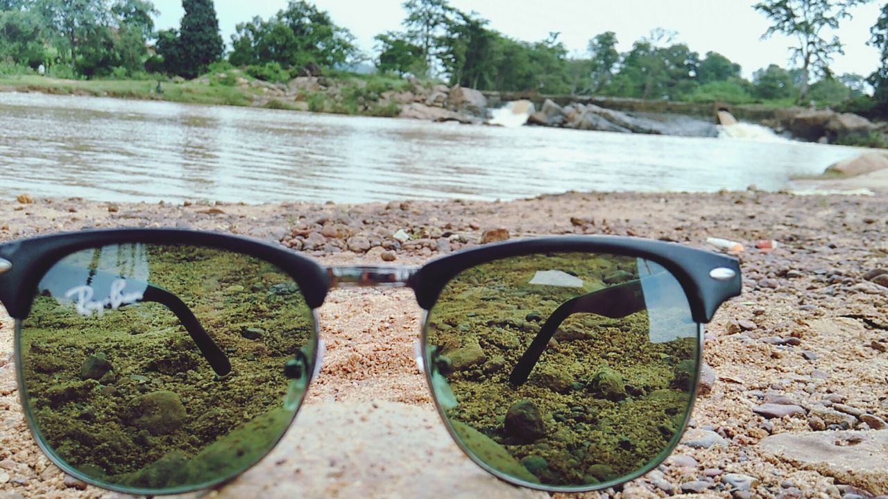 CLOSE-UP OF SUNGLASSES ON WATER