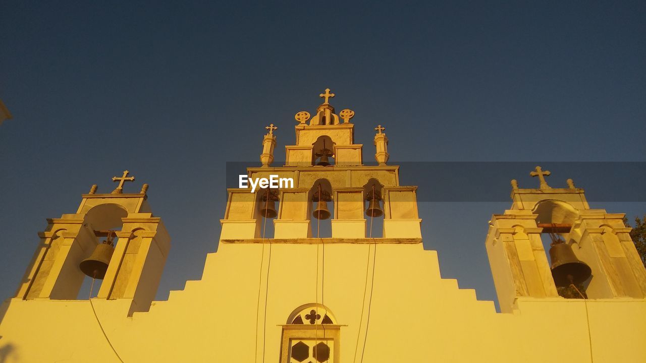 Low angle view of old church against clear sky during sunset