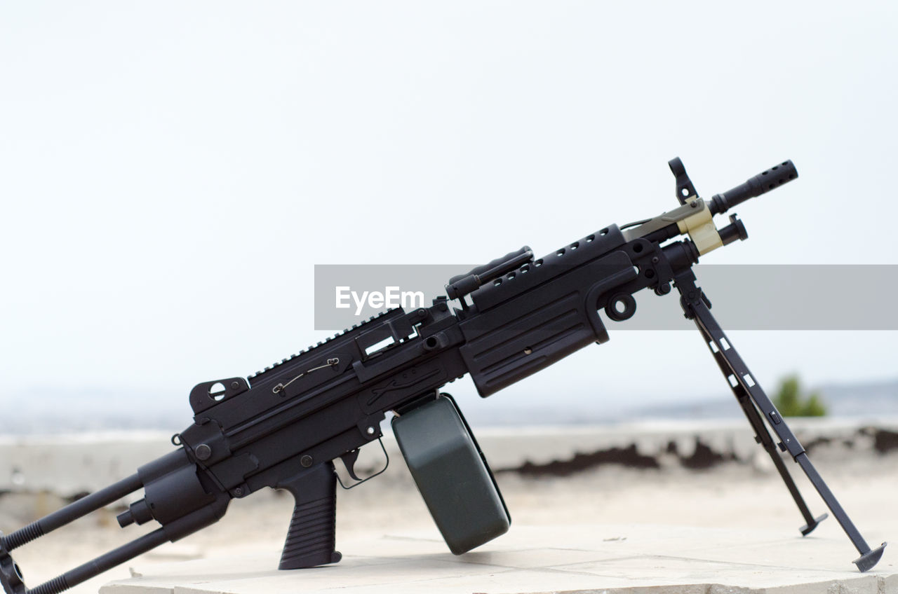 Close-up of gun against sky