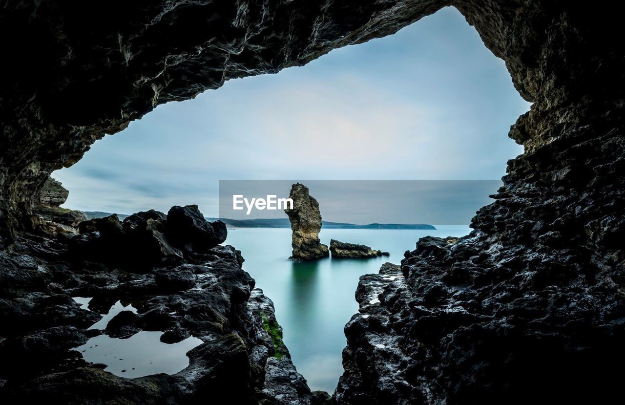 Rock formations in sea against sky