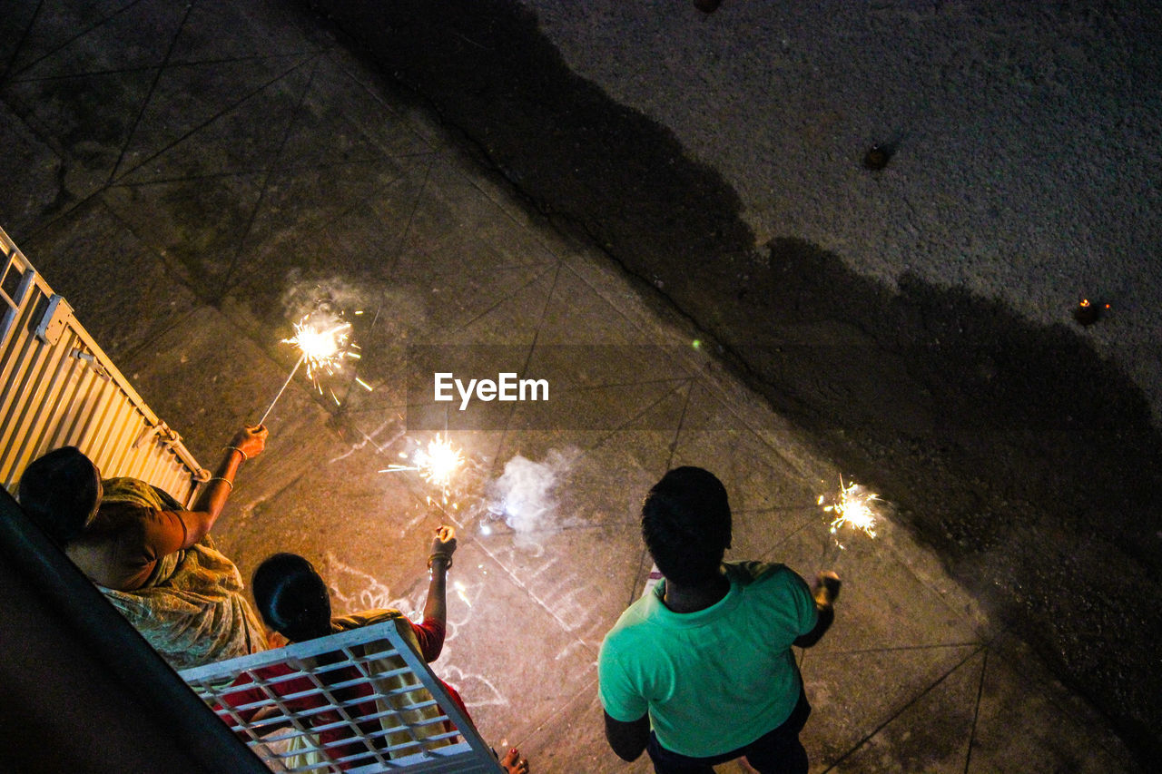 High angle view of people with sparklers at night