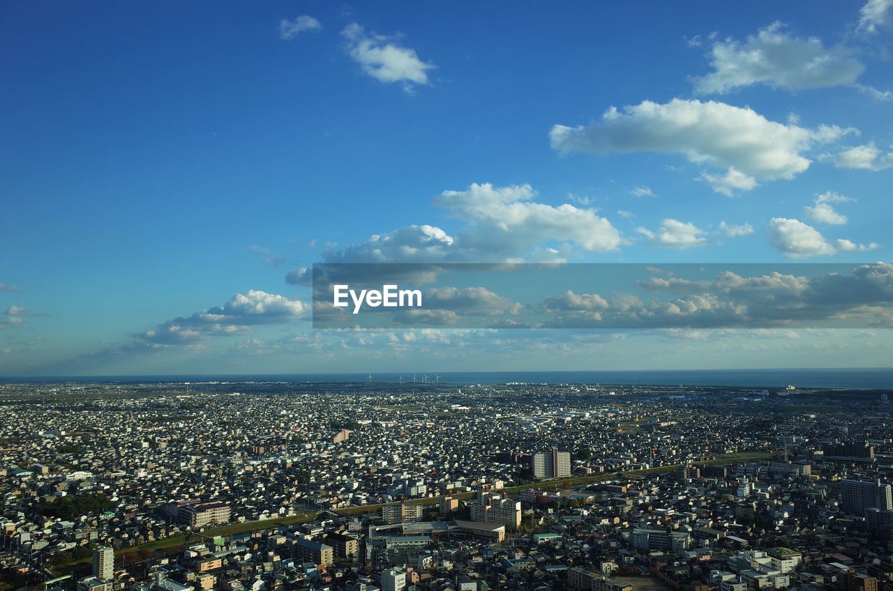 Aerial view of cityscape against blue sky