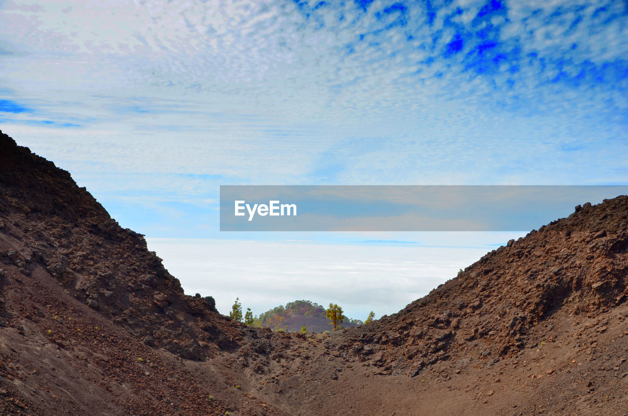 SCENIC VIEW OF MOUNTAINS AGAINST CLOUDY SKY