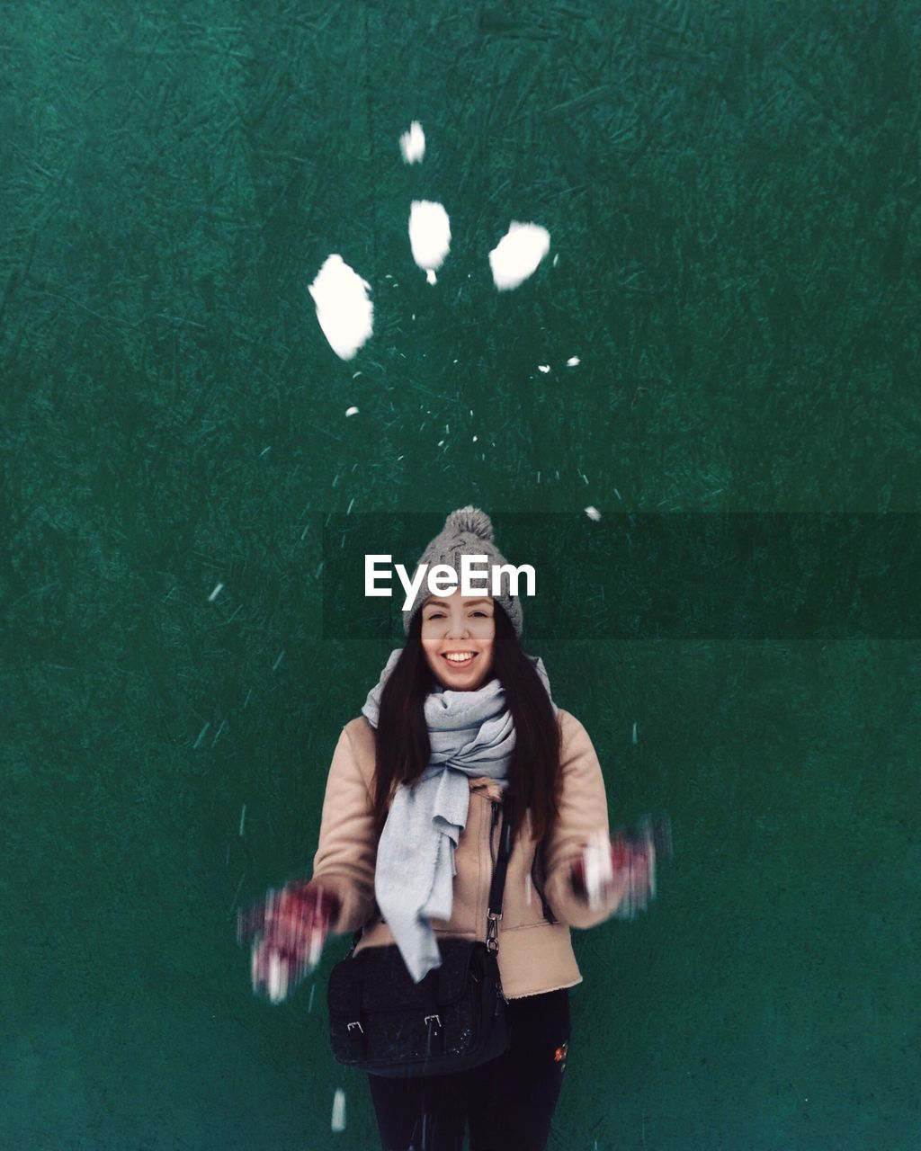 Portrait of woman throwing snow