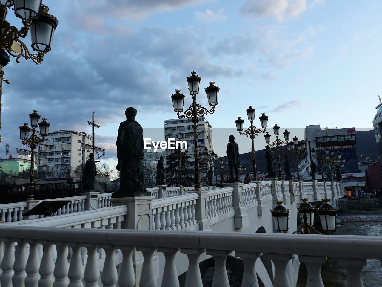 PEOPLE IN CITY BY WATER AGAINST SKY