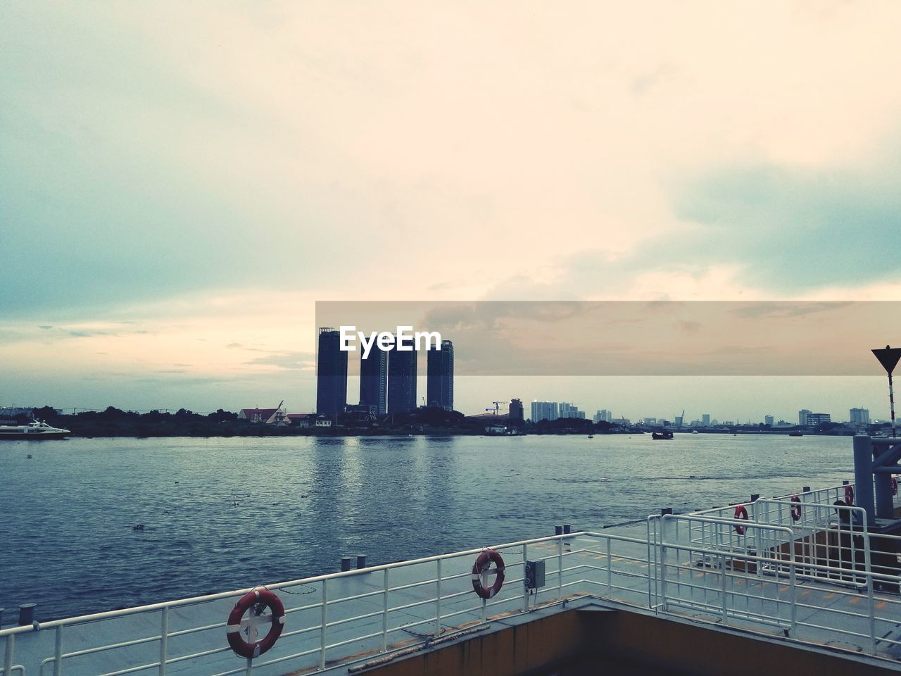 Scenic view of sea by buildings against sky during sunset