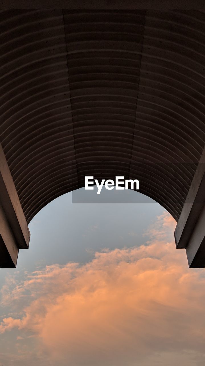 LOW ANGLE VIEW OF BRIDGE AGAINST SKY AT SUNSET