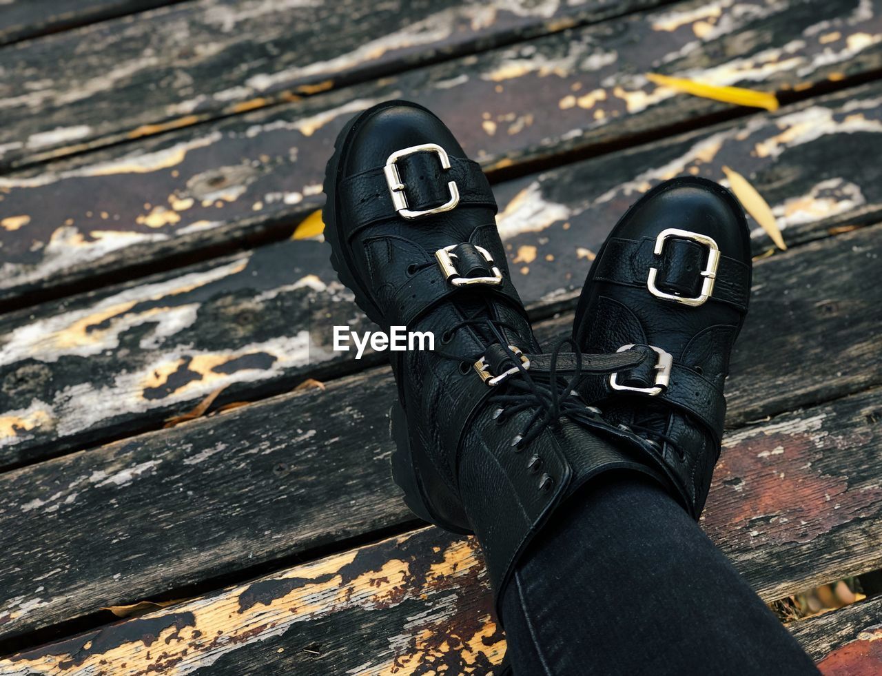Low section of woman wearing black shoes on wood