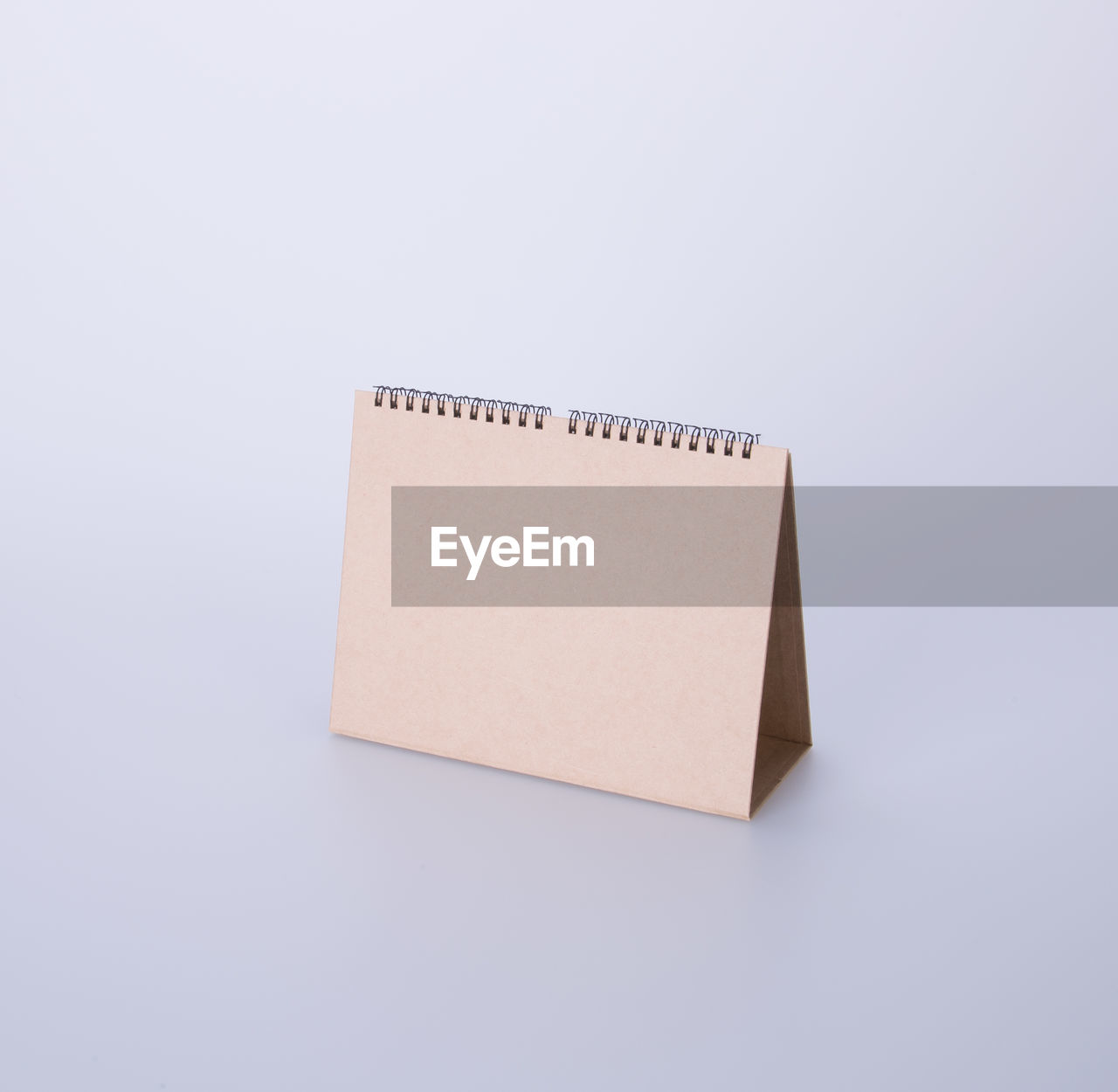 High angle view of blank brown desk calendar on white background