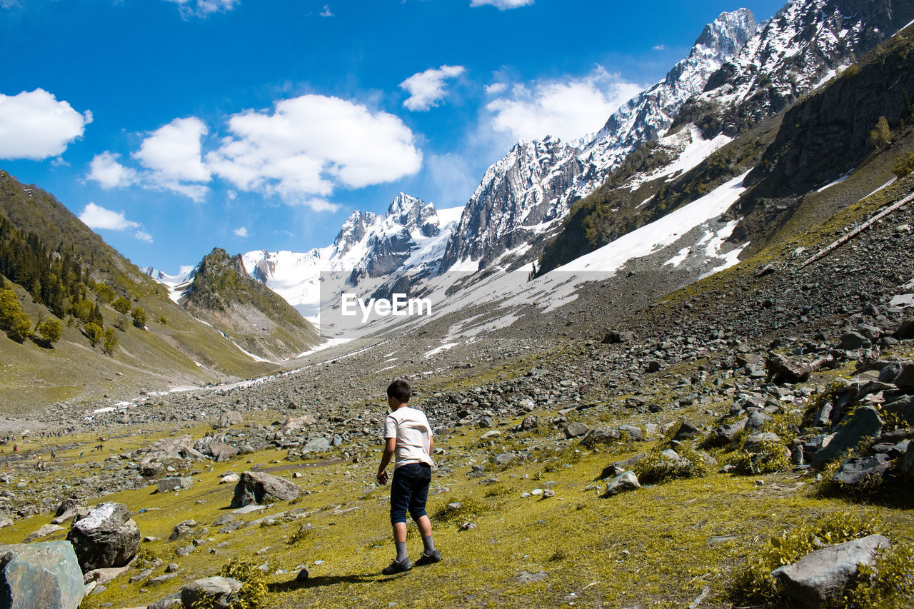 Rear view of boy walking on mountain