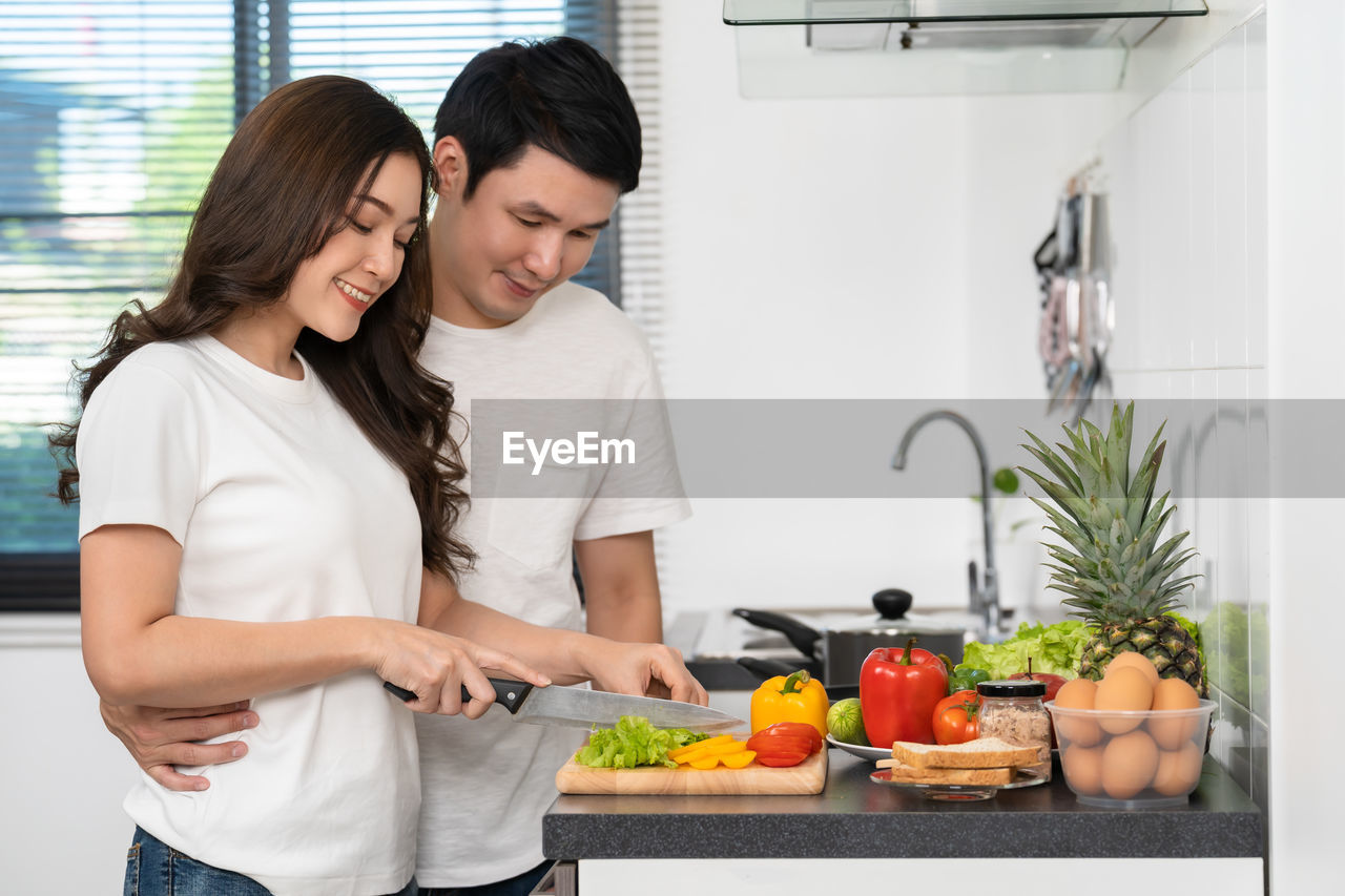 young woman preparing food in kitchen at home