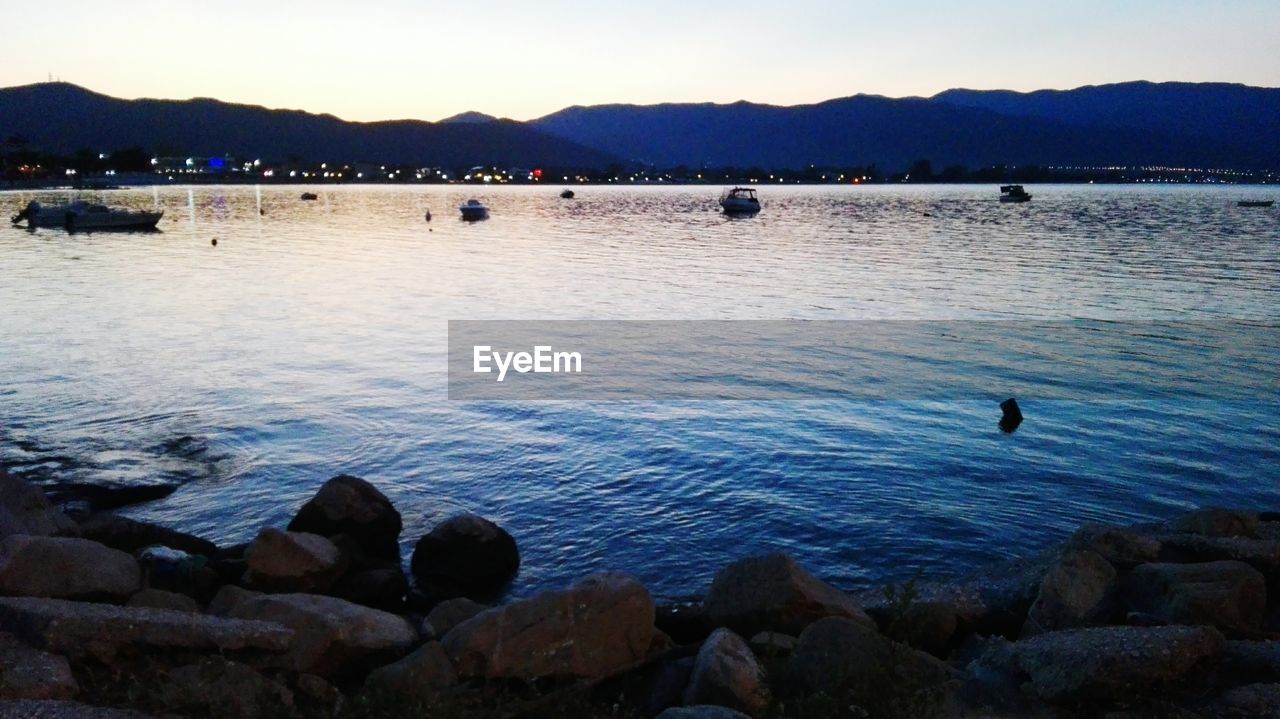 DUCKS SWIMMING IN LAKE AGAINST SKY