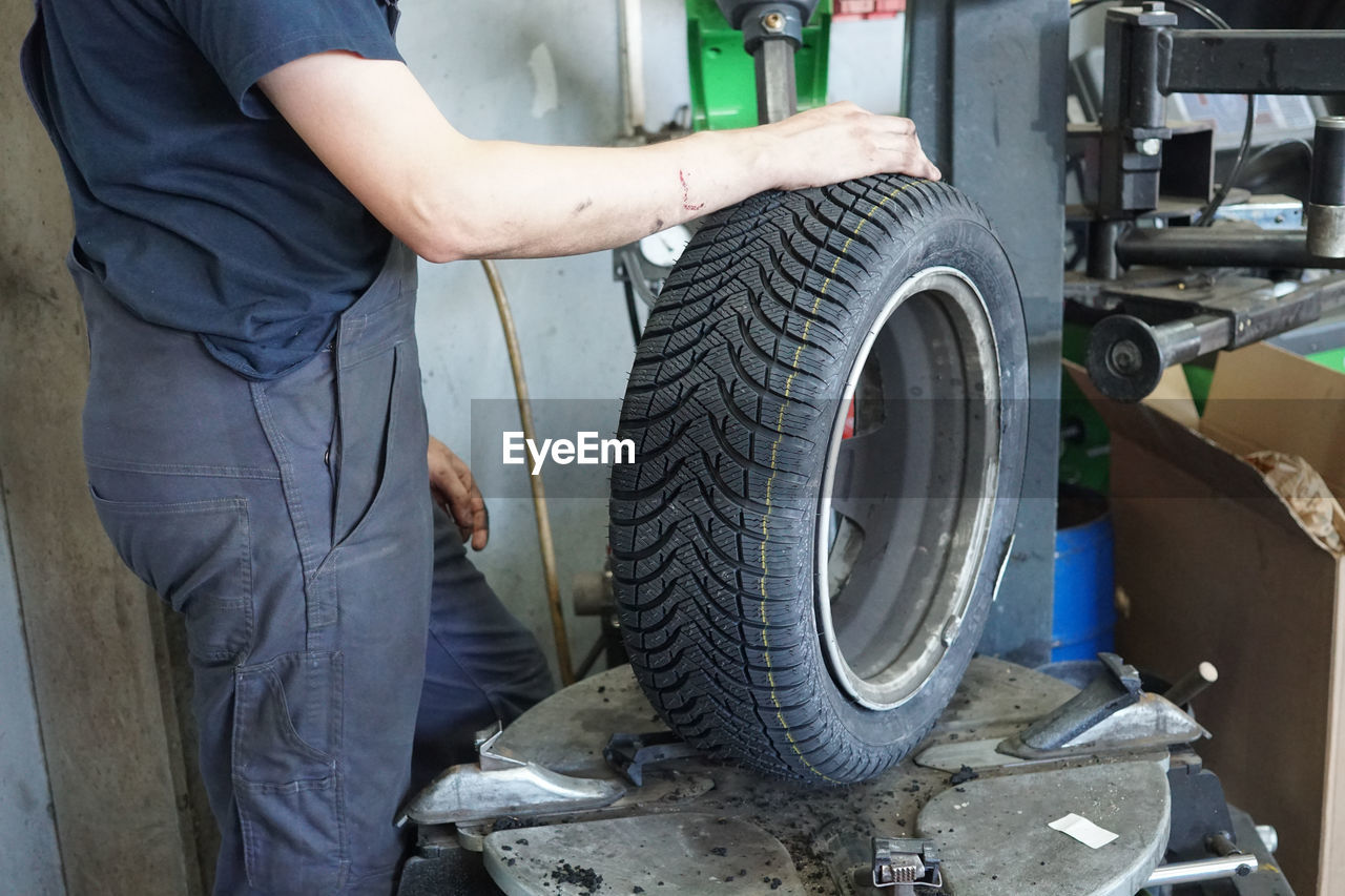 Low angle view of man holding tire