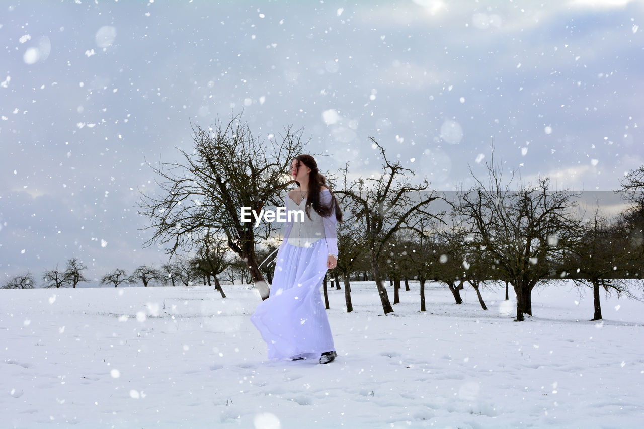 Woman standing on snow covered field