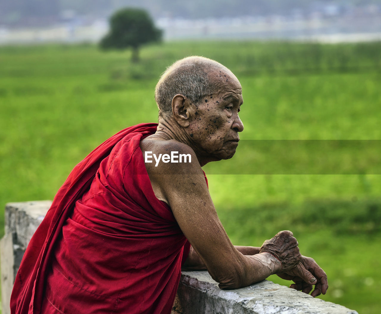 Senior monk in traditional clothing standing outdoors