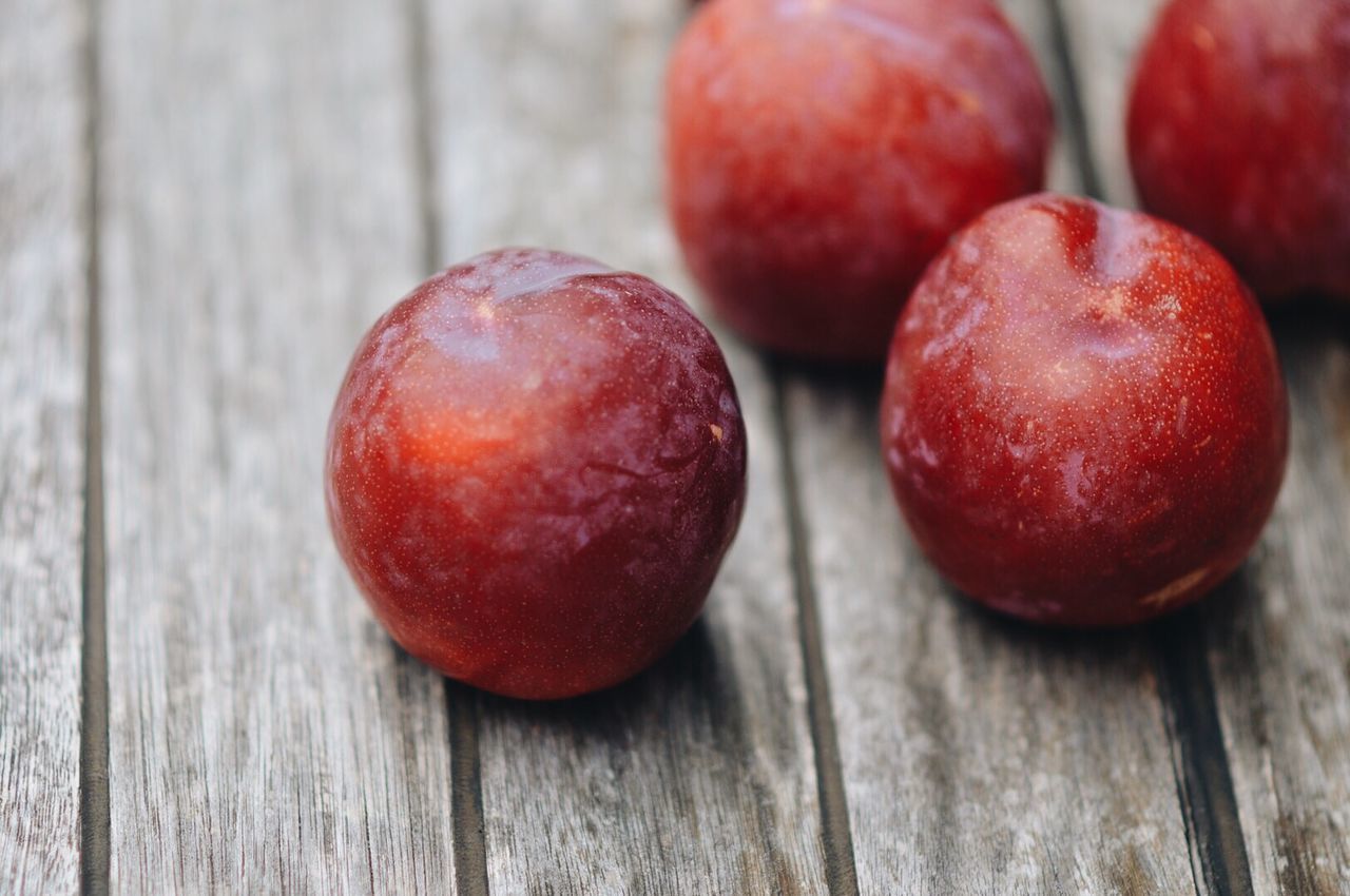 Close-up of plums on wooden table