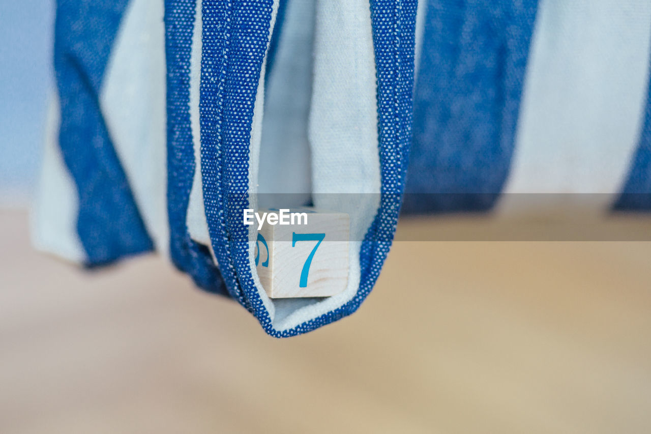 Close-up of wooden block in white and blue textile