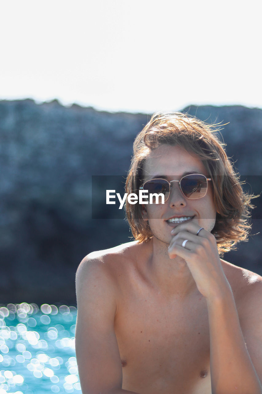 Close up portrait of man enjoying freedom on luxury yacht deck relaxing on boat summer vacation.