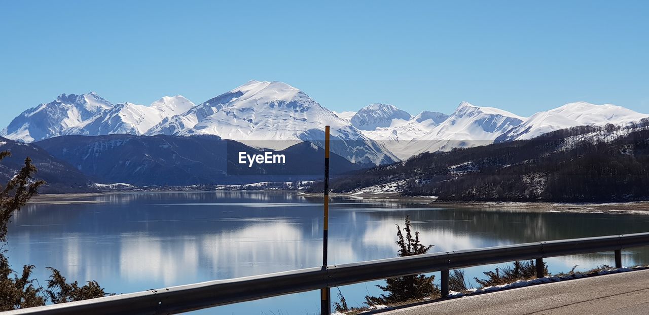 Scenic view of snowcapped mountains against clear blue sky