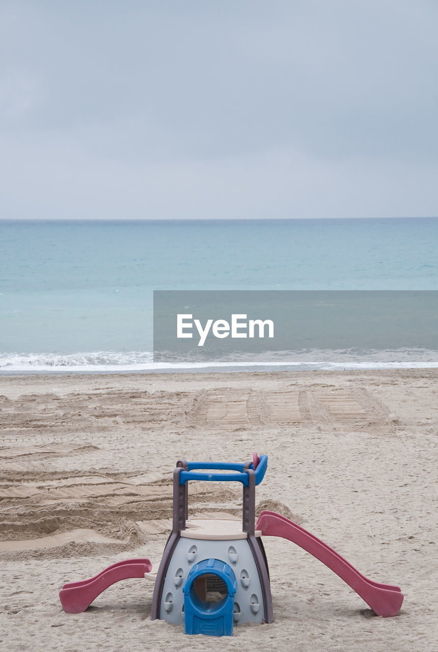 DECK CHAIRS ON SHORE AGAINST SKY