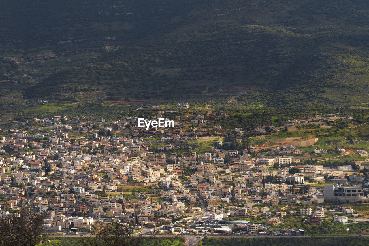 A view of a populated area village in a green valley in the morning at sunrise, against a dramatic