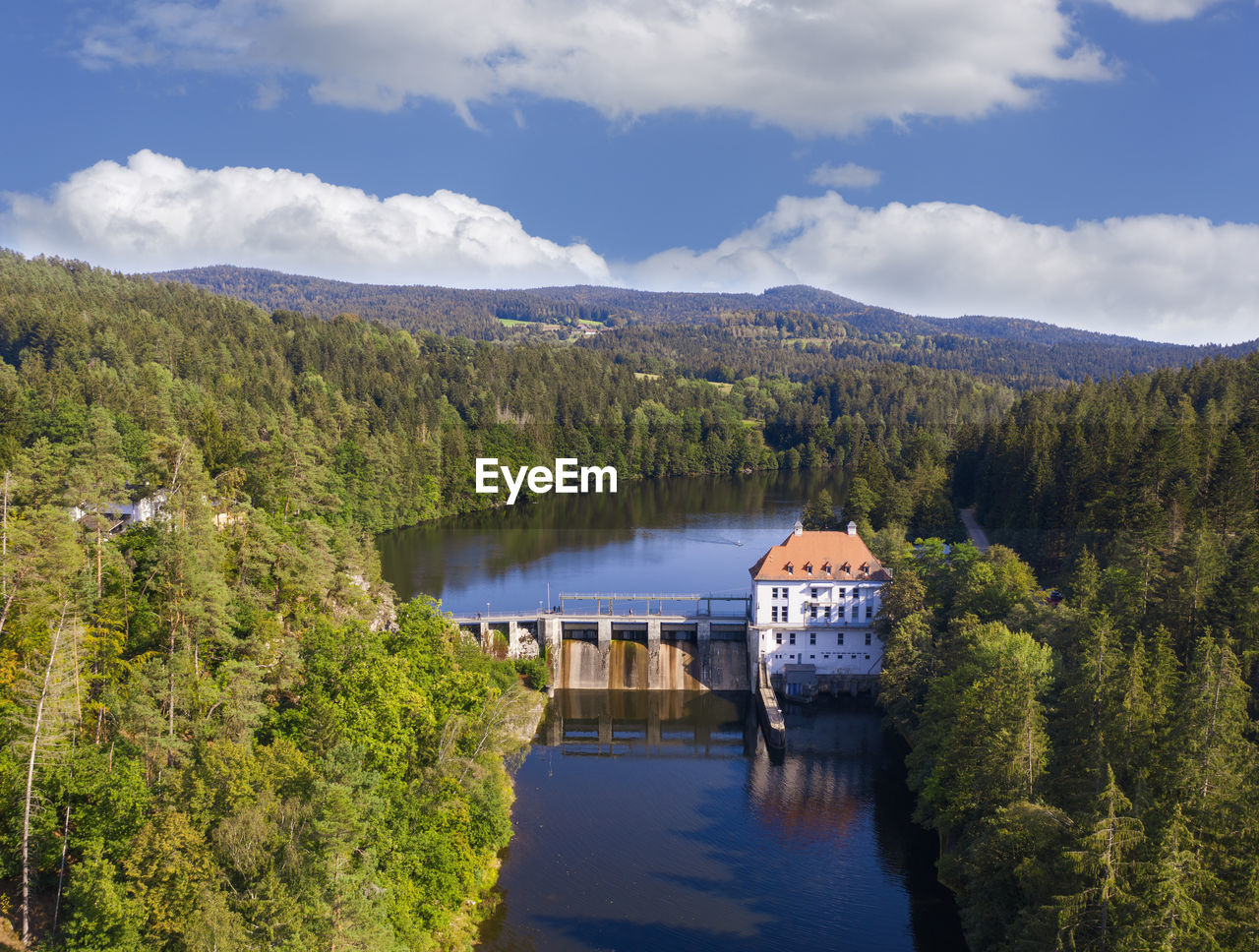 Drone view of hydroelectric power station on hollensteinsee lake and surrounding forest in summer