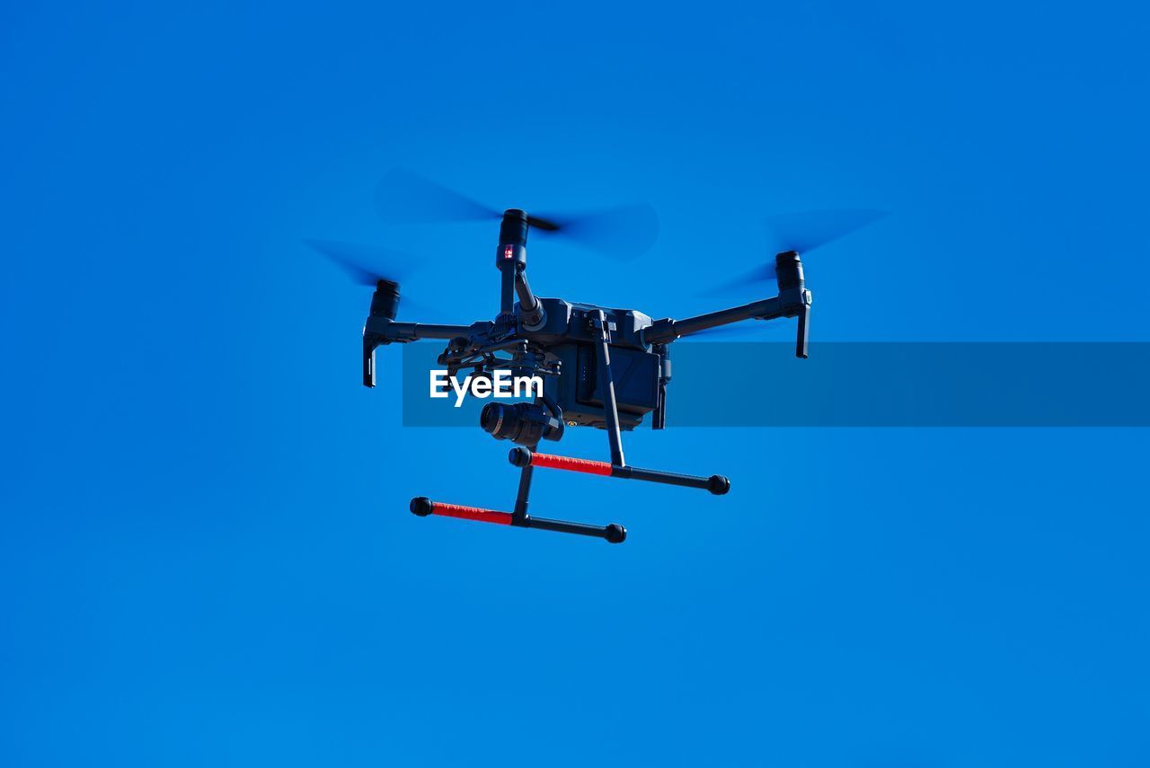 Low angle view of airplane against clear blue sky