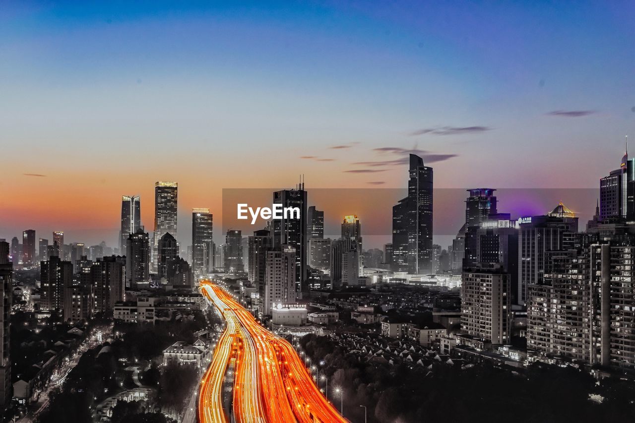 High angle view of cityscape against clear blue sky during sunset