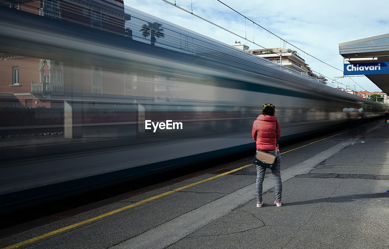 Rear view of man walking on railroad station platform