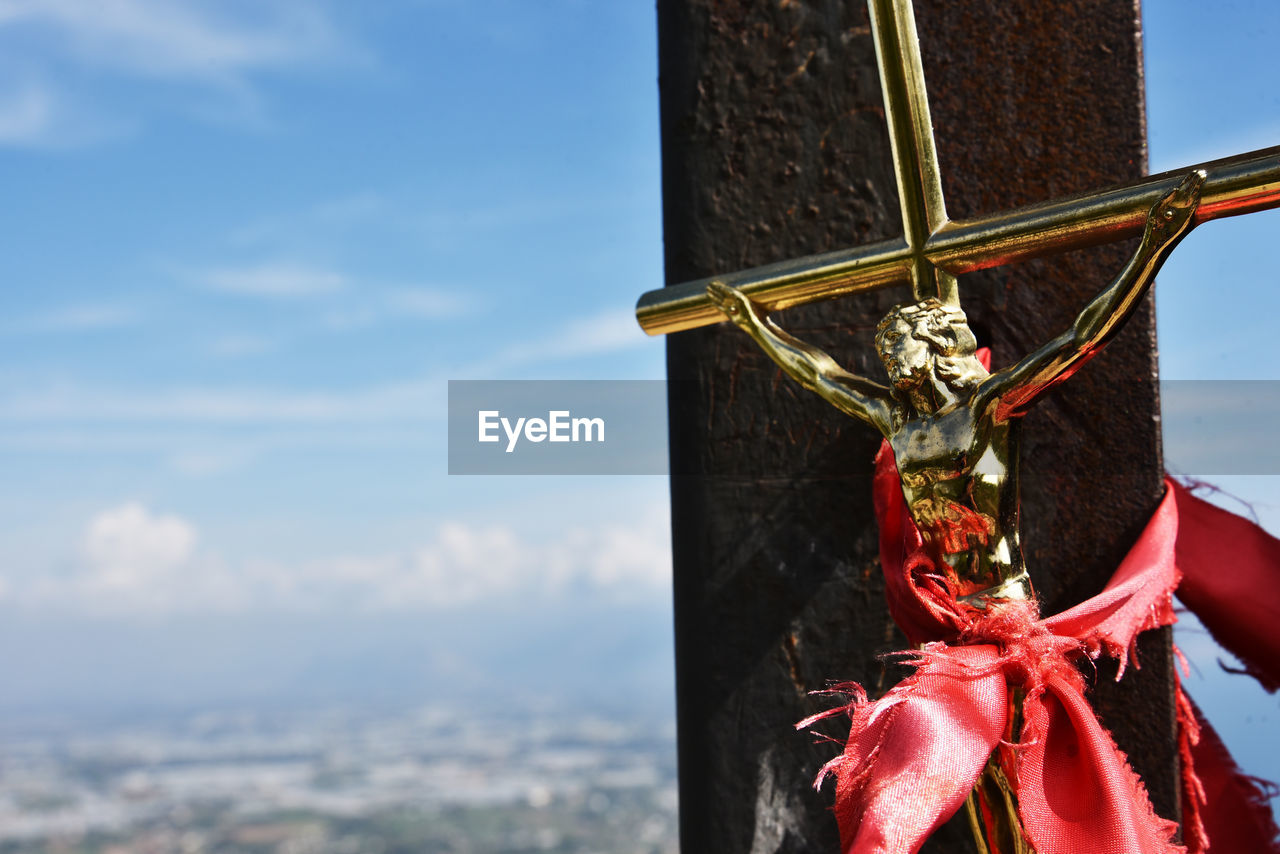 low angle view of cross against cloudy sky