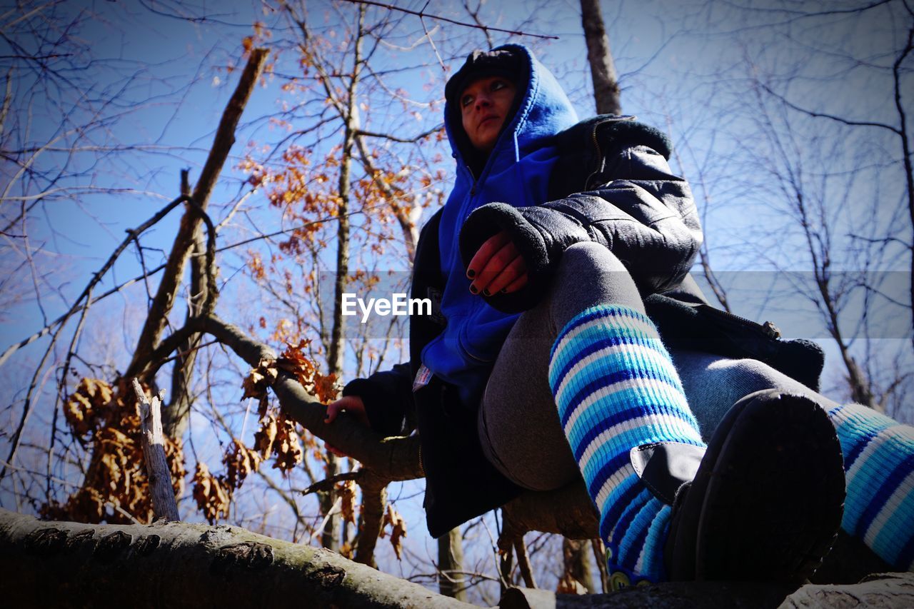 LOW ANGLE VIEW OF PEOPLE SITTING IN PARK