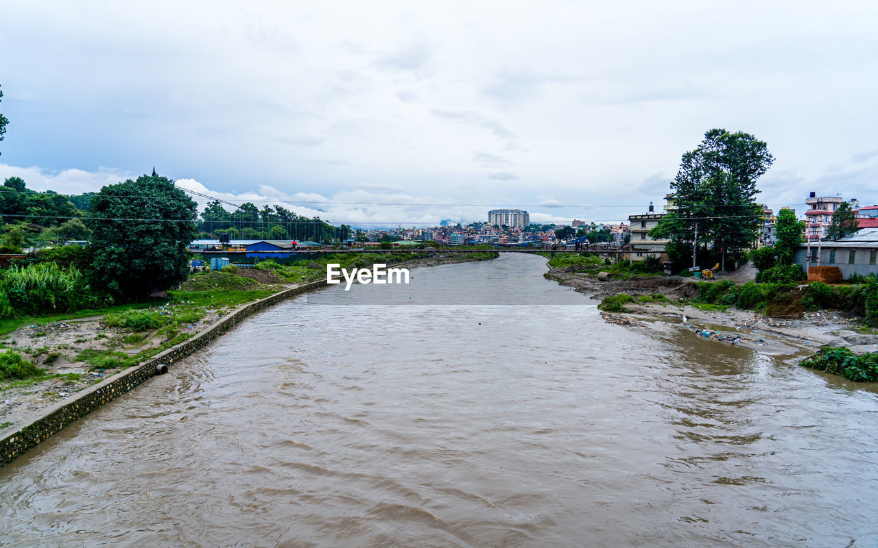 river, water, architecture, sky, cloud, built structure, nature, building exterior, environment, city, tree, building, plant, body of water, travel destinations, land, travel, waterway, landscape, outdoors, tourism, no people, day, house, beauty in nature, holiday, vacation, trip, residential district, beach