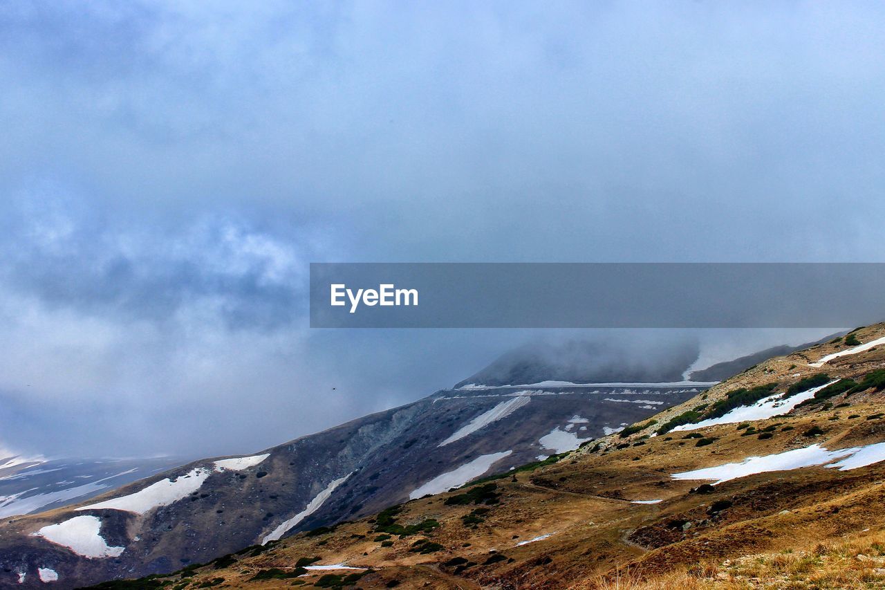 SCENIC VIEW OF MOUNTAINS AGAINST SKY DURING WINTER