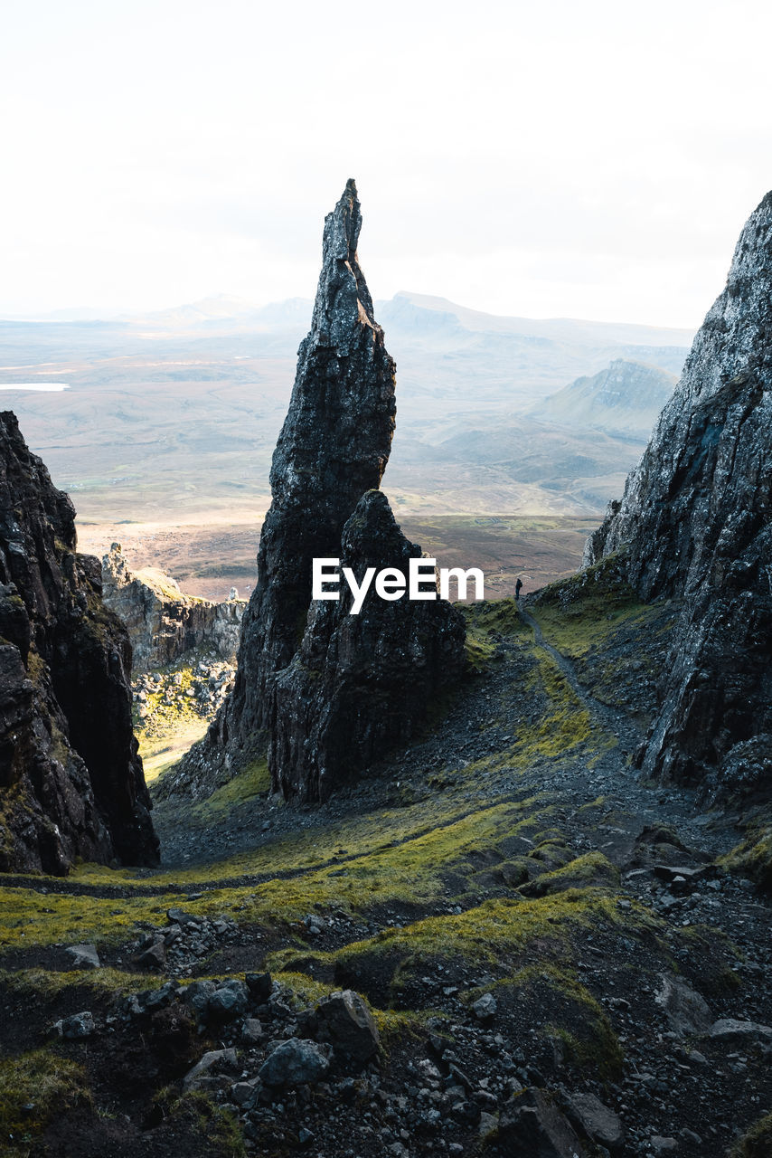 A hiker next to the needle in the quiraing region on the isle of skye.