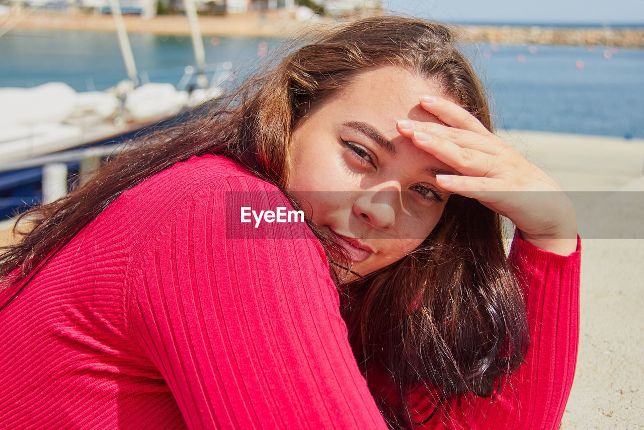 Portrait of young woman standing at beach