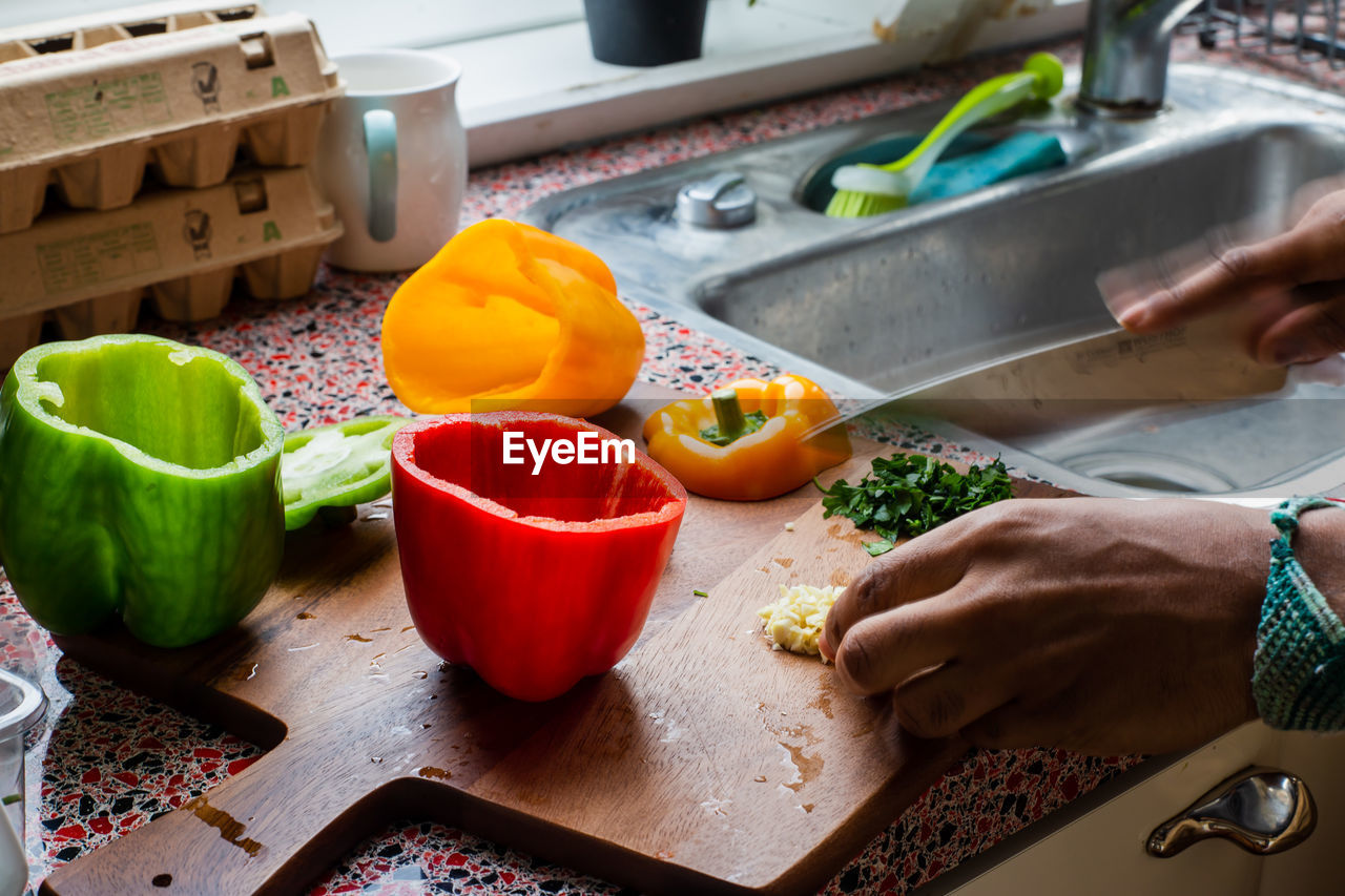 MIDSECTION OF MAN PREPARING FOOD IN KITCHEN