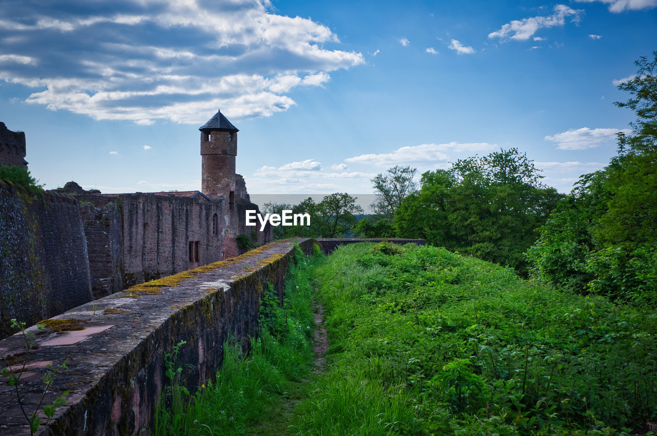 architecture, sky, history, the past, built structure, cloud, plant, nature, travel destinations, rural area, travel, hill, building, building exterior, environment, landscape, tree, wall, tourism, castle, land, no people, ancient, outdoors, château, fort, old, scenics - nature, medieval, blue, tower, water, ruins, old ruin, security, religion, beauty in nature, city, stone material, protection, grass