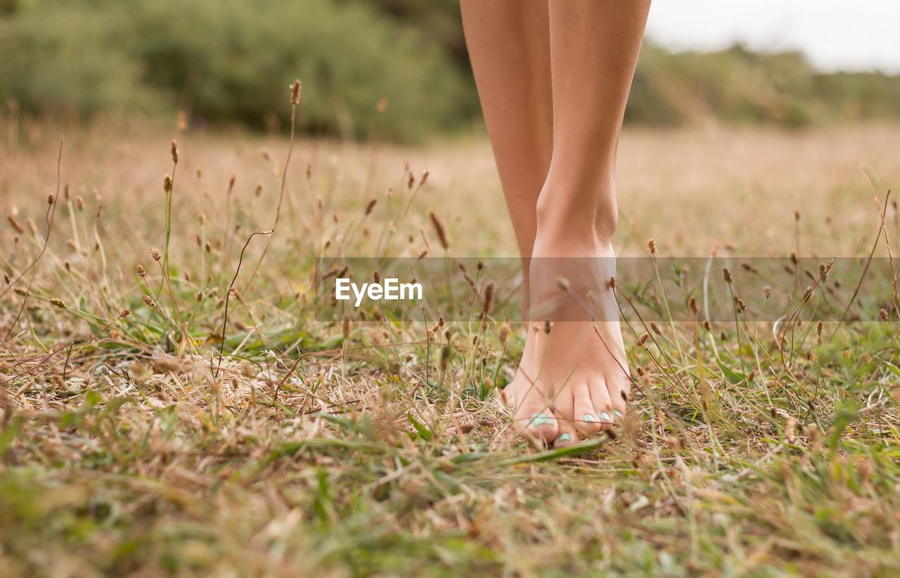 LOW SECTION OF WOMAN STANDING ON GROUND