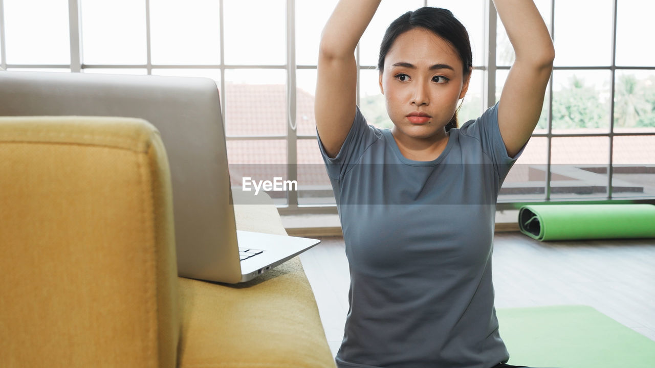 Yoga exercise at home concept. asian young woman practice yoga while watching yoga tutorial