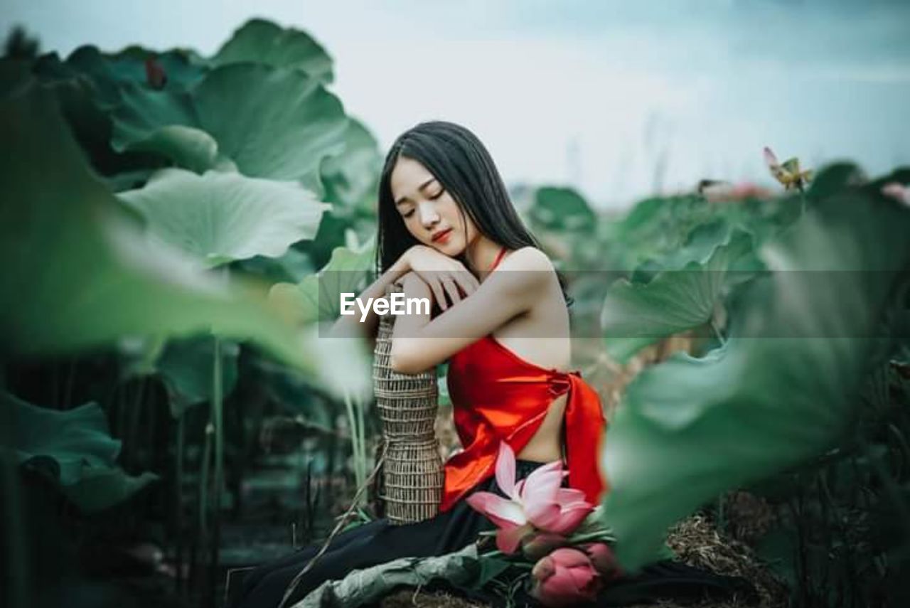 Portrait of woman standing against plants