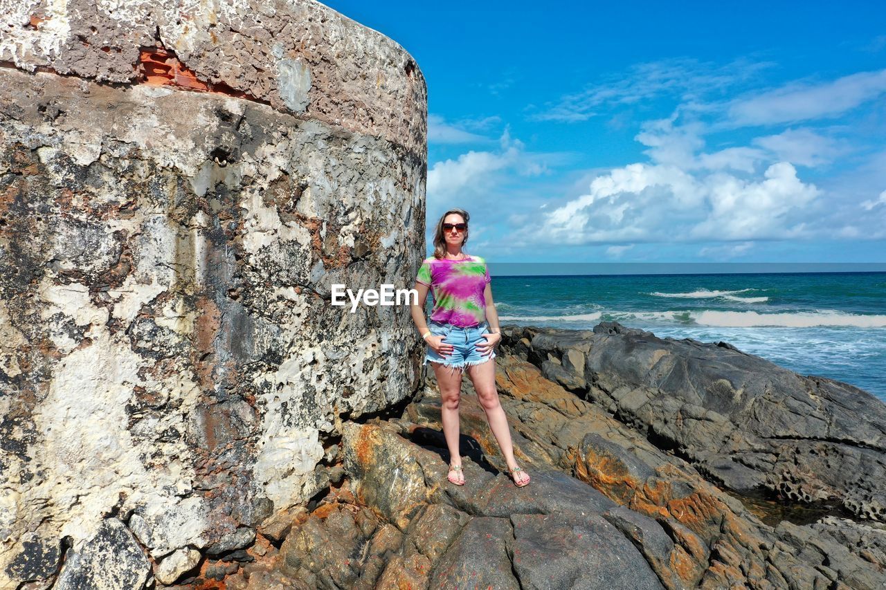 FULL LENGTH PORTRAIT OF MAN STANDING ON ROCK