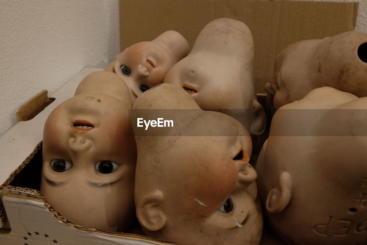 Close-up of broken dolls in box