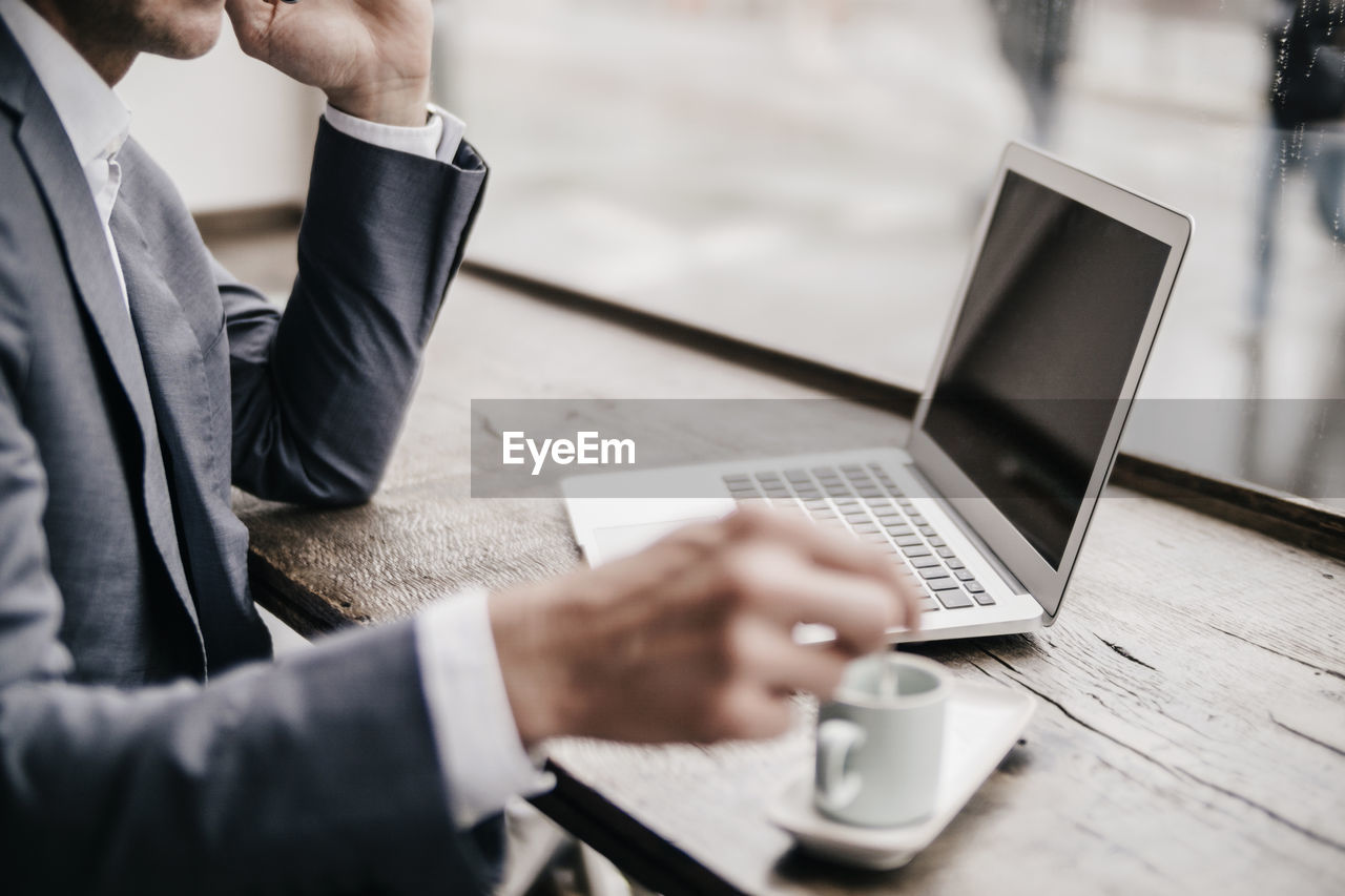 Businessman working in coffee shop, close up