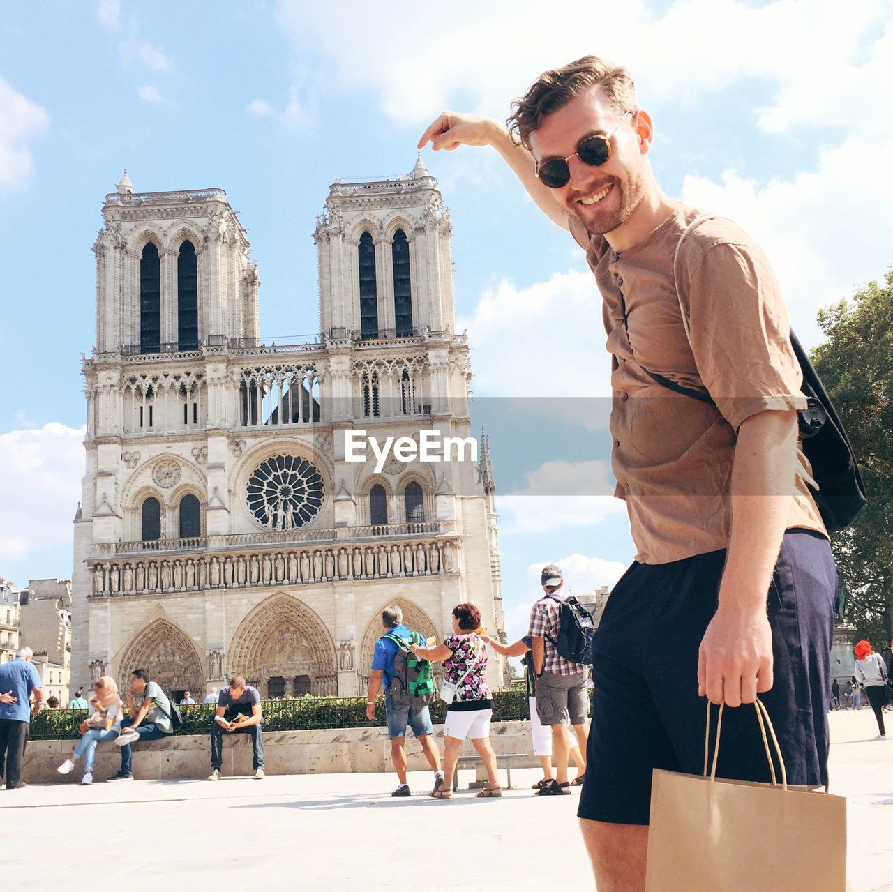 Portrait of man pointing at notre dame