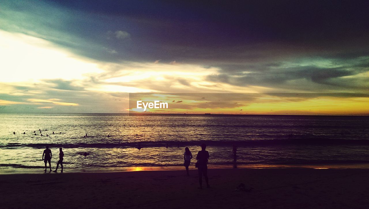 Group of people on beach at sunset