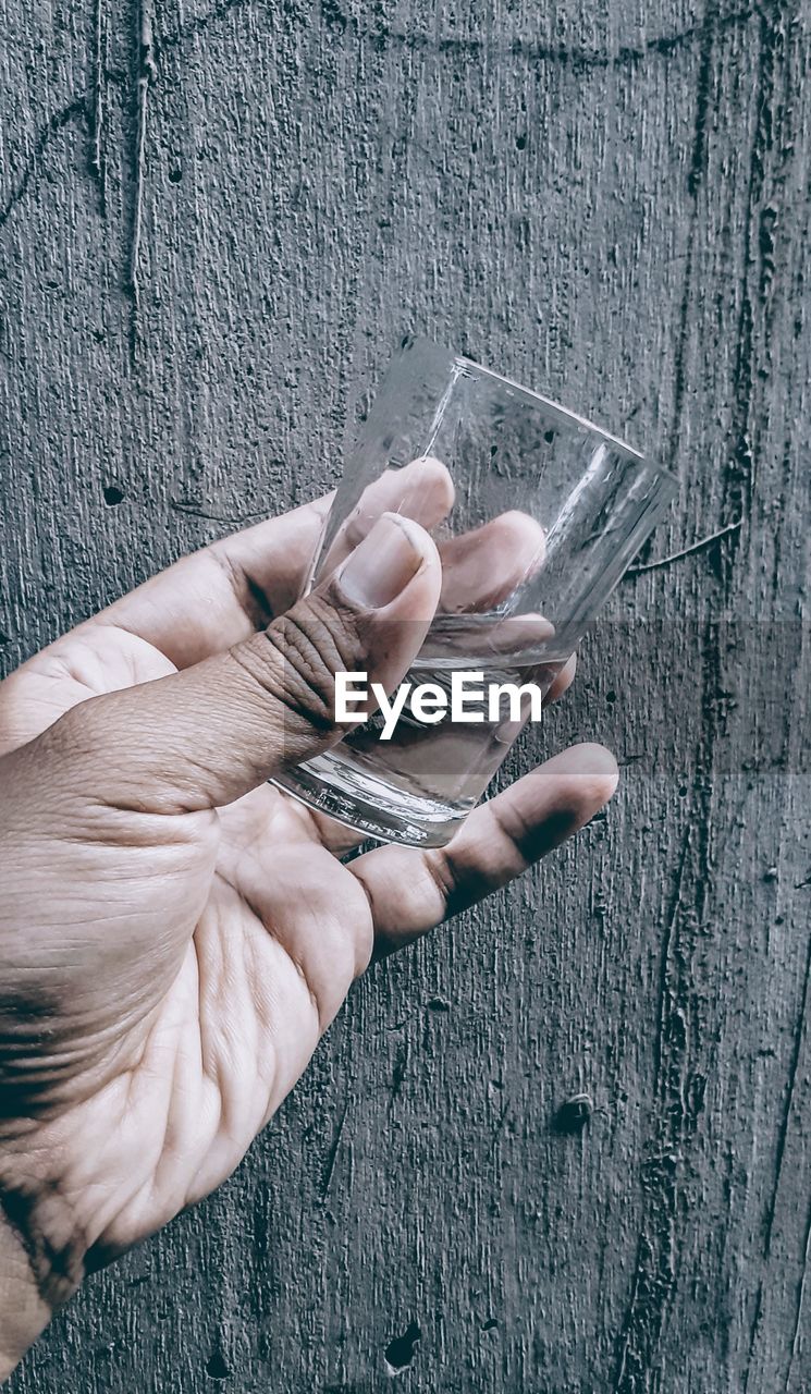 High angle view of person hand holding glass