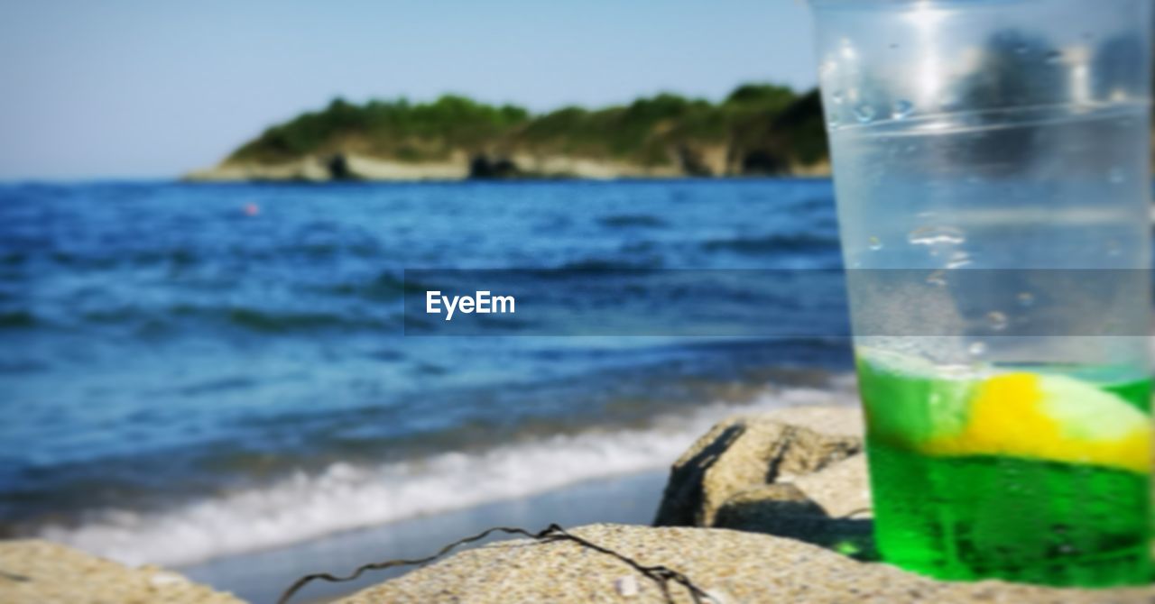 CLOSE-UP OF GLASS OF WATER ON ROCK