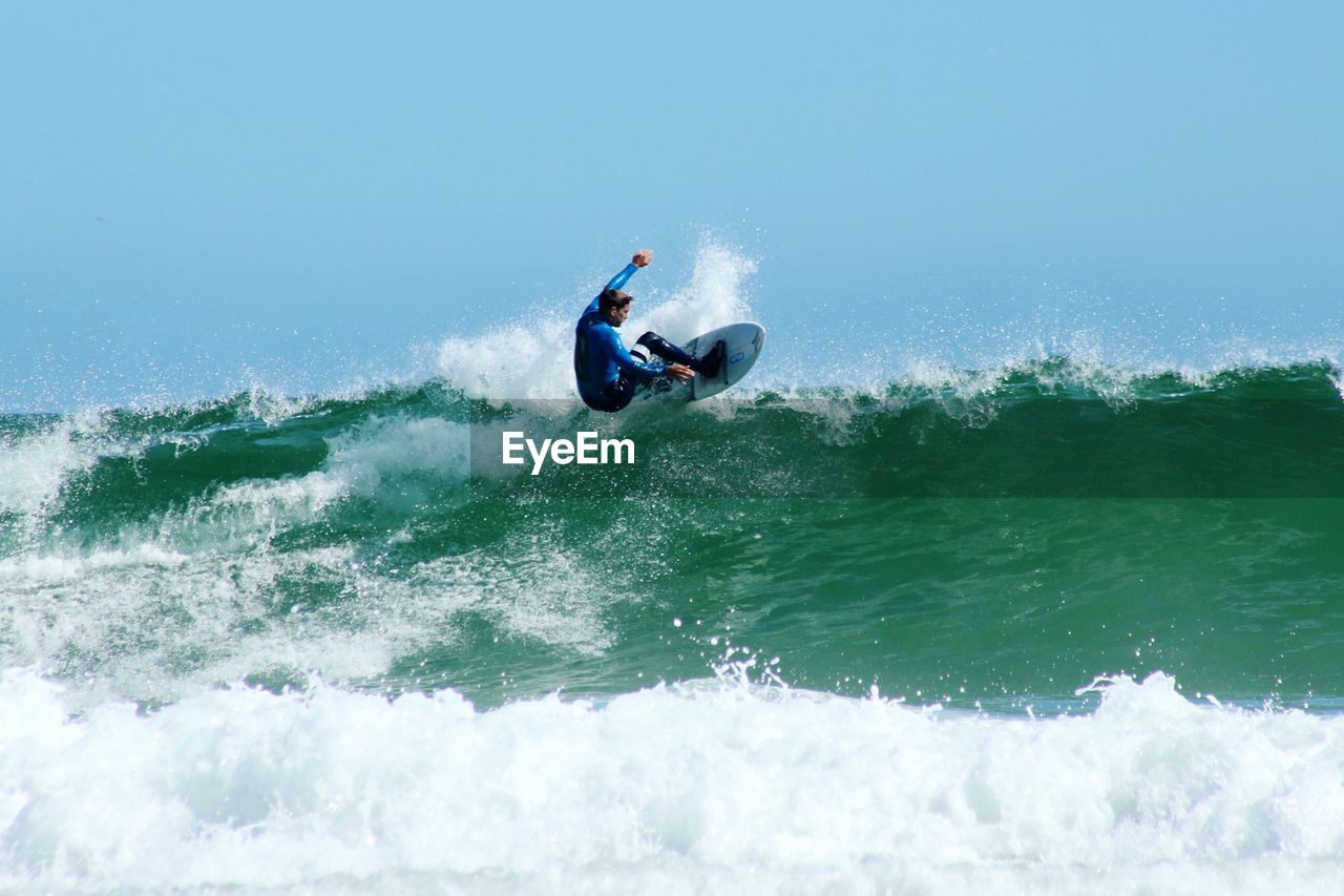 Man surfing at sea against clear sky