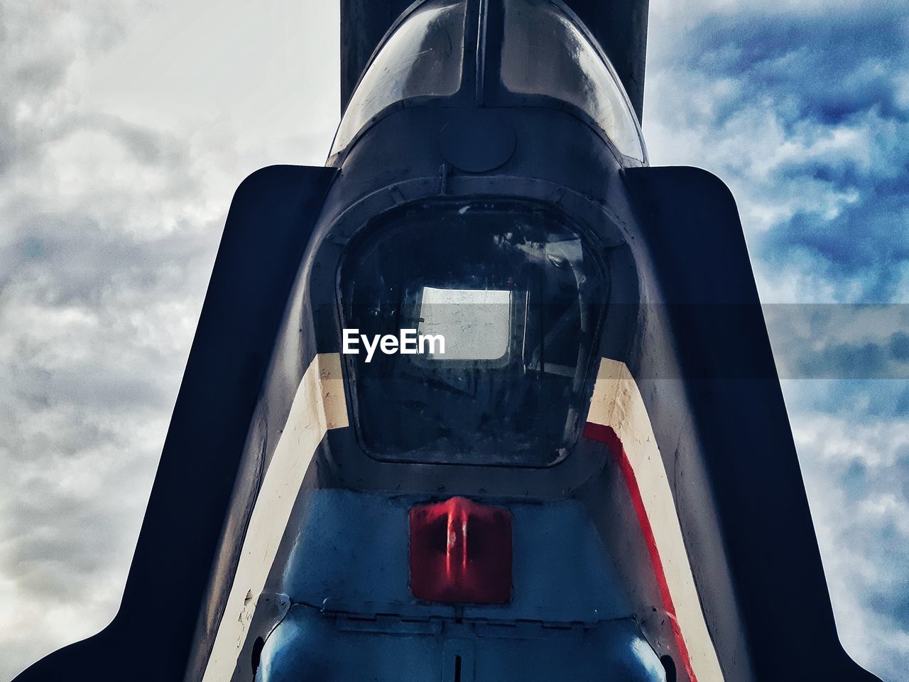 Low angle view of airplane against cloudy sky