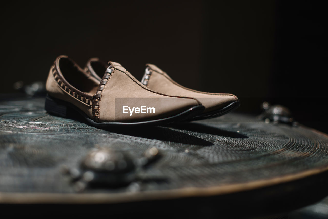 Close-up of shoes on table against black background